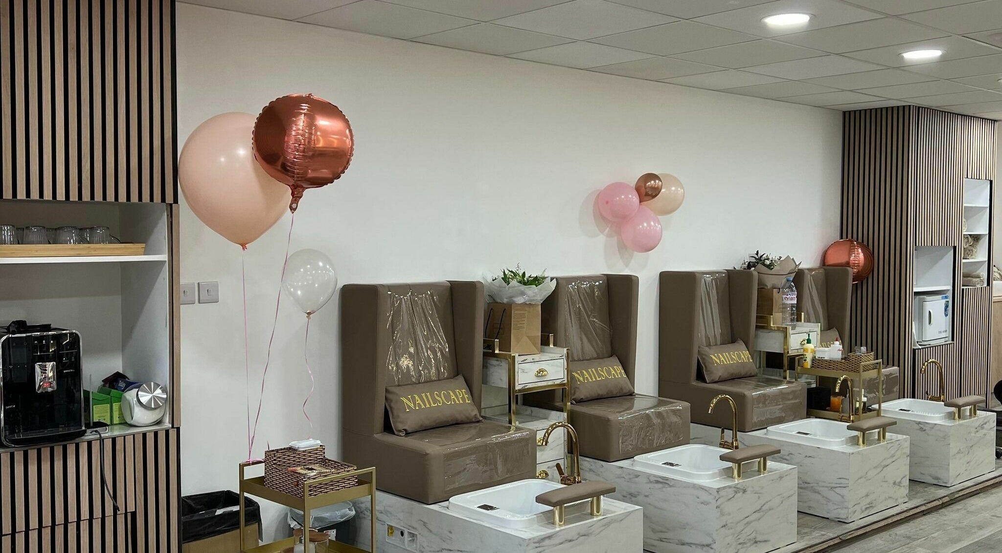 Elegant pedicure stations at NAILSCAPE Ealing, London, England, GB with chic seating and balloons.