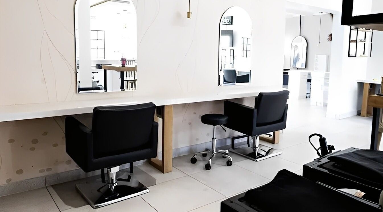 Salon at 102 in Rustenburg, North West, ZA, showcases modern styling stations with sleek mirrors and chairs.