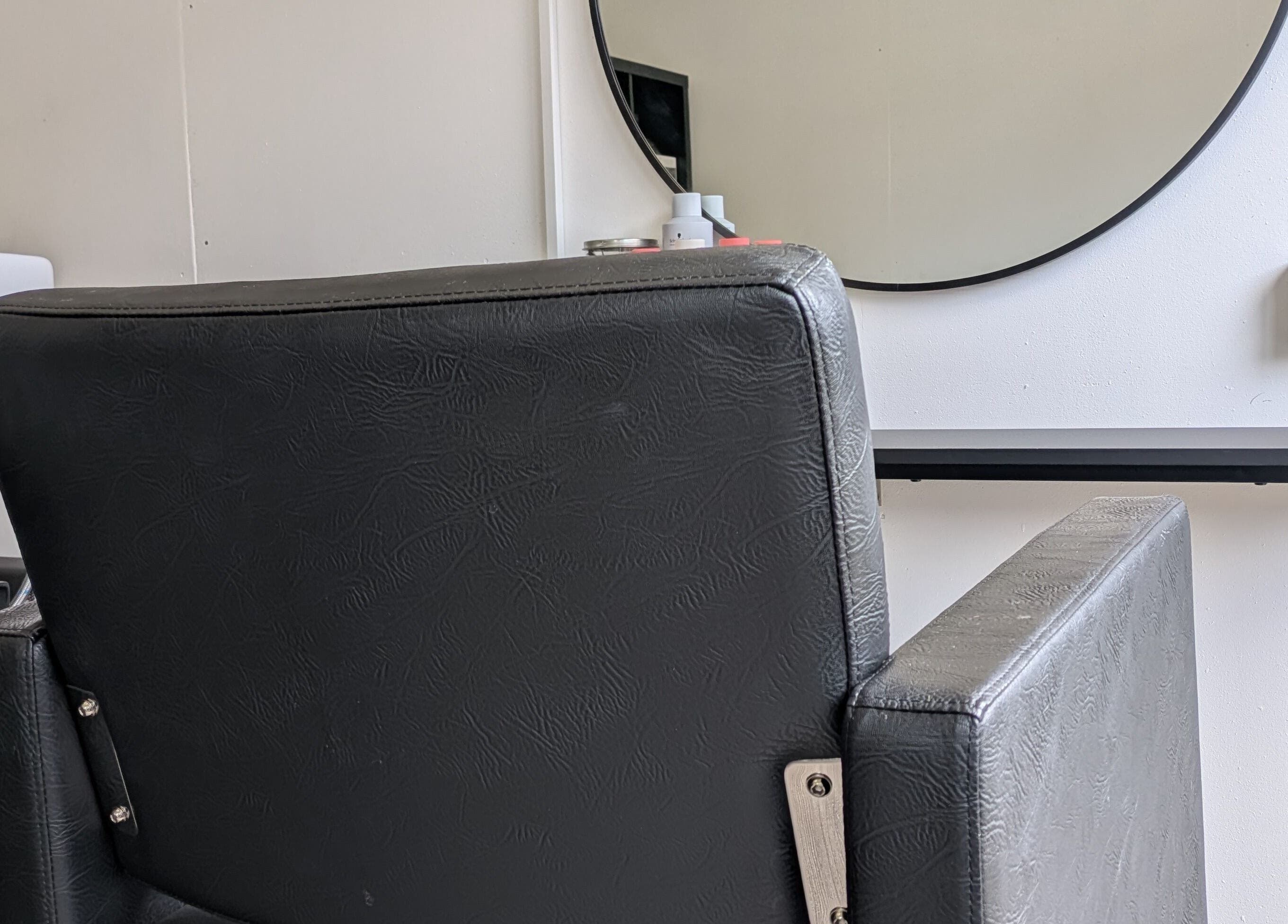 Modern salon chair at Abbie Bellchambers Hair Salon in Shepshed, England, GB, with a stylish mirror backdrop.