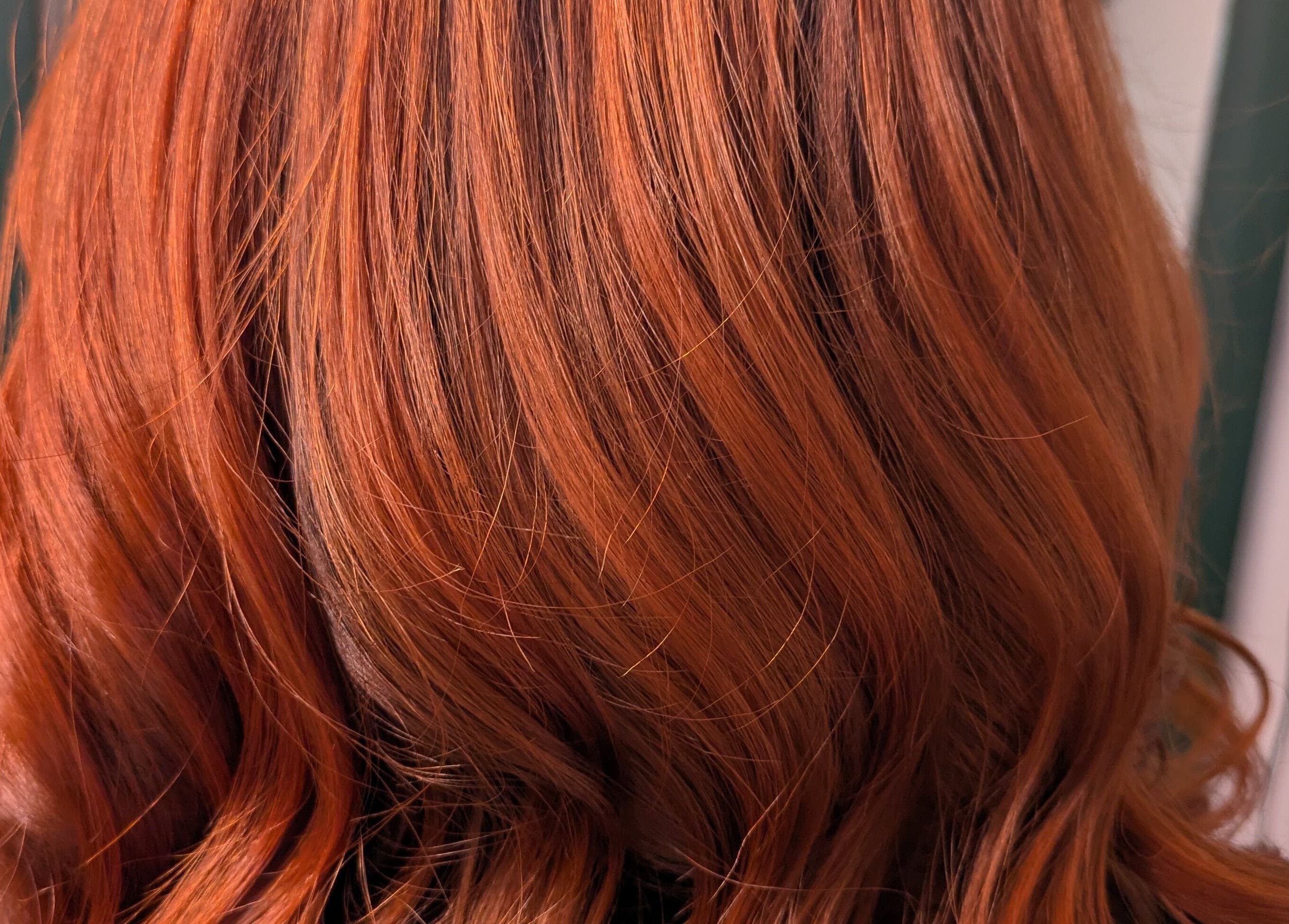 Vibrant red hair styled at Abbie Bellchambers Hair Salon in Shepshed, England, GB, showcasing sleek and glossy texture.