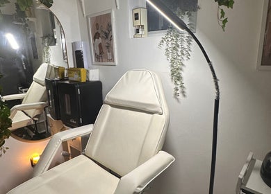 Relaxing treatment room at Crown Beauty and Aesthetics, London, England, GB, featuring a plush chair and soft lighting.