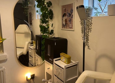 Cozy treatment room at Crown Beauty and Aesthetics in London, England, GB, adorned with plants and warm lighting.