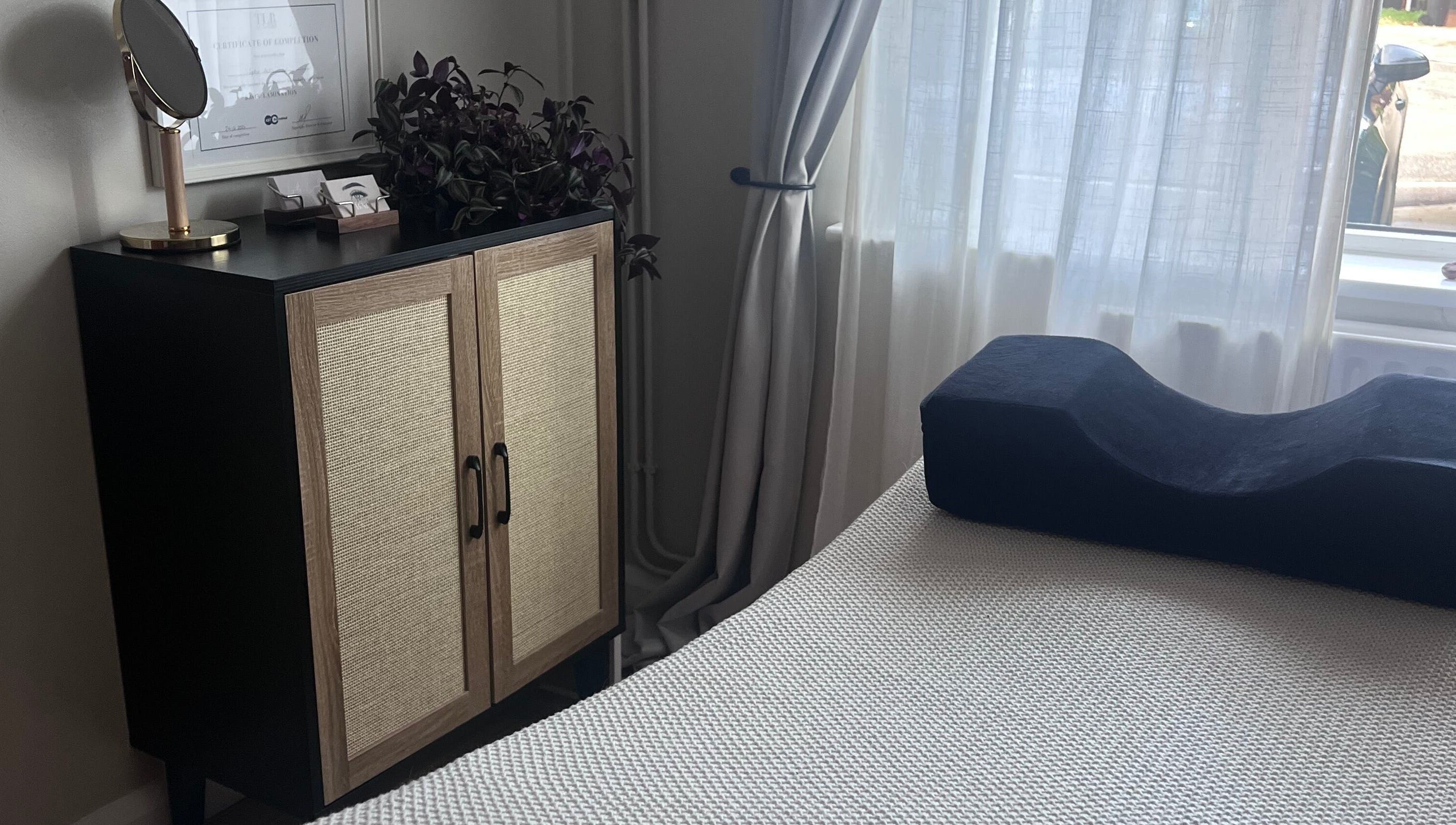 Relaxing room setup at Sophie's beauty bar, Midhurst, England, GB, featuring a cabinet and soft lighting.