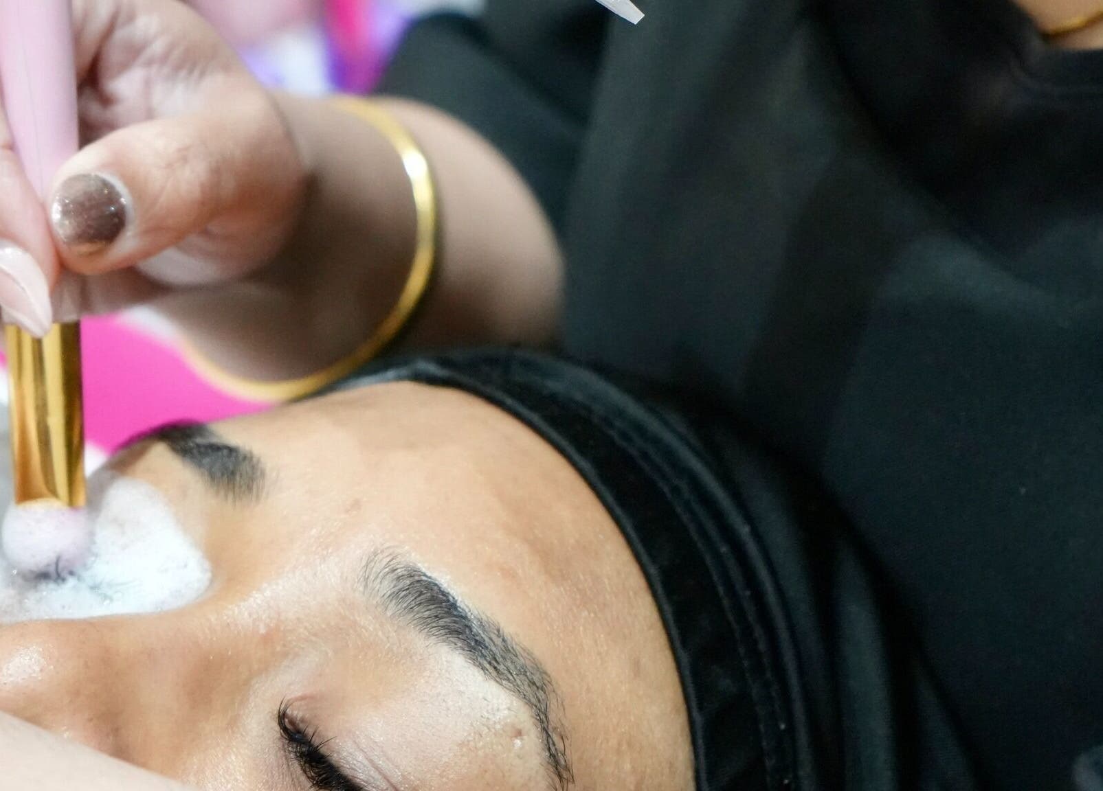 Close-up of facial treatment at Wink Spa in Feltham, England, GB, showing careful application with a brush.