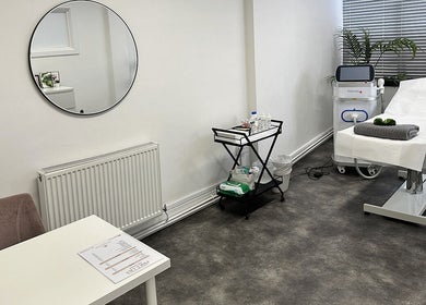 Spacious treatment room at Olga Genc Beauty in Chichester, England, GB, featuring a modern therapy bed and equipment.