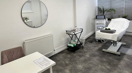 Spacious treatment room at Olga Genc Beauty in Chichester, England, GB, featuring a modern therapy bed and equipment.