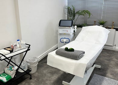 Modern treatment room at Olga Genc Beauty, Chichester, England, GB featuring a comfortable spa bed and equipment.
