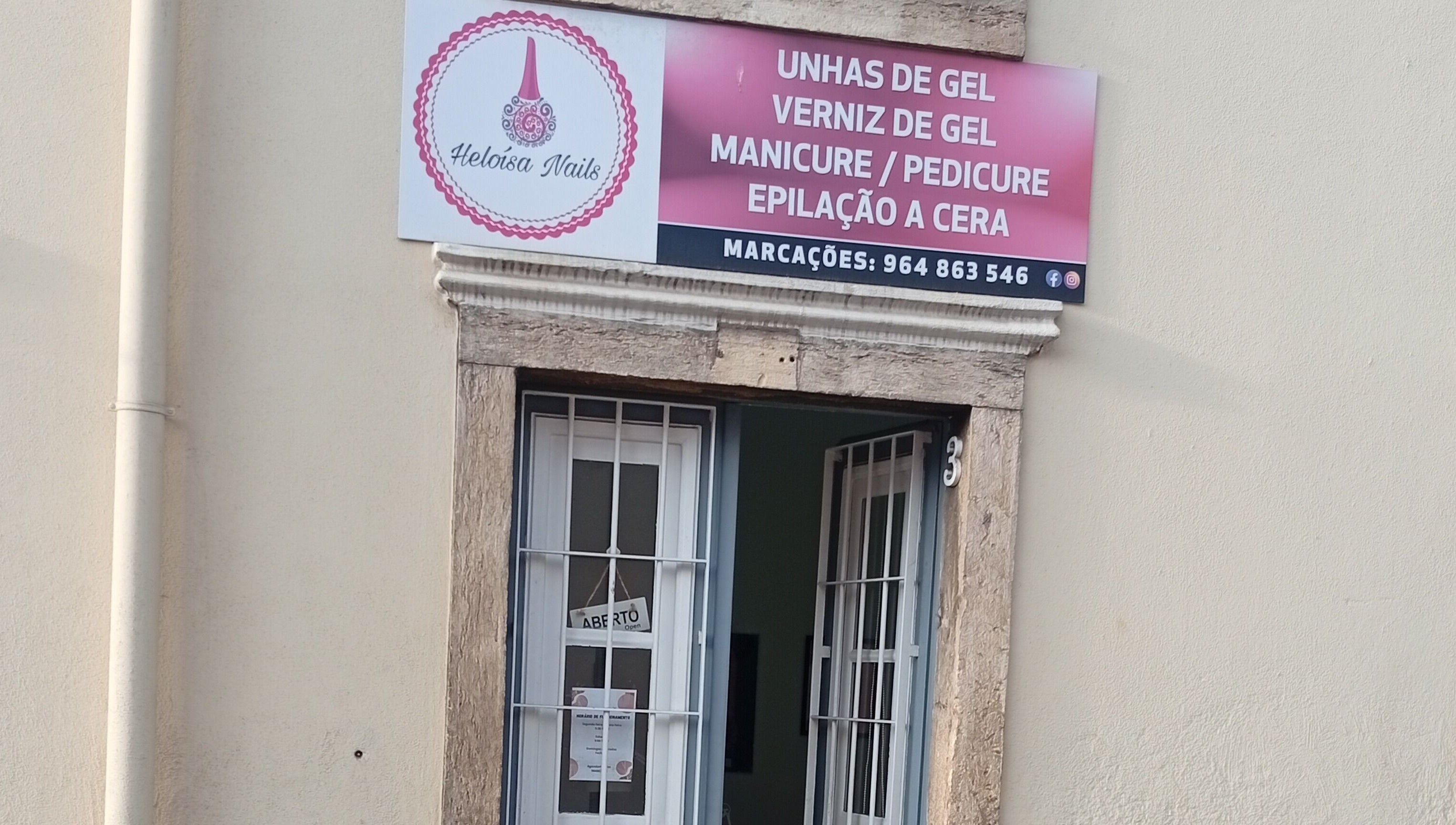 Entrada de Heloísa Nails Salon em Lisboa, Lisboa, PT com placa destacando serviços de manicure e pedicure.