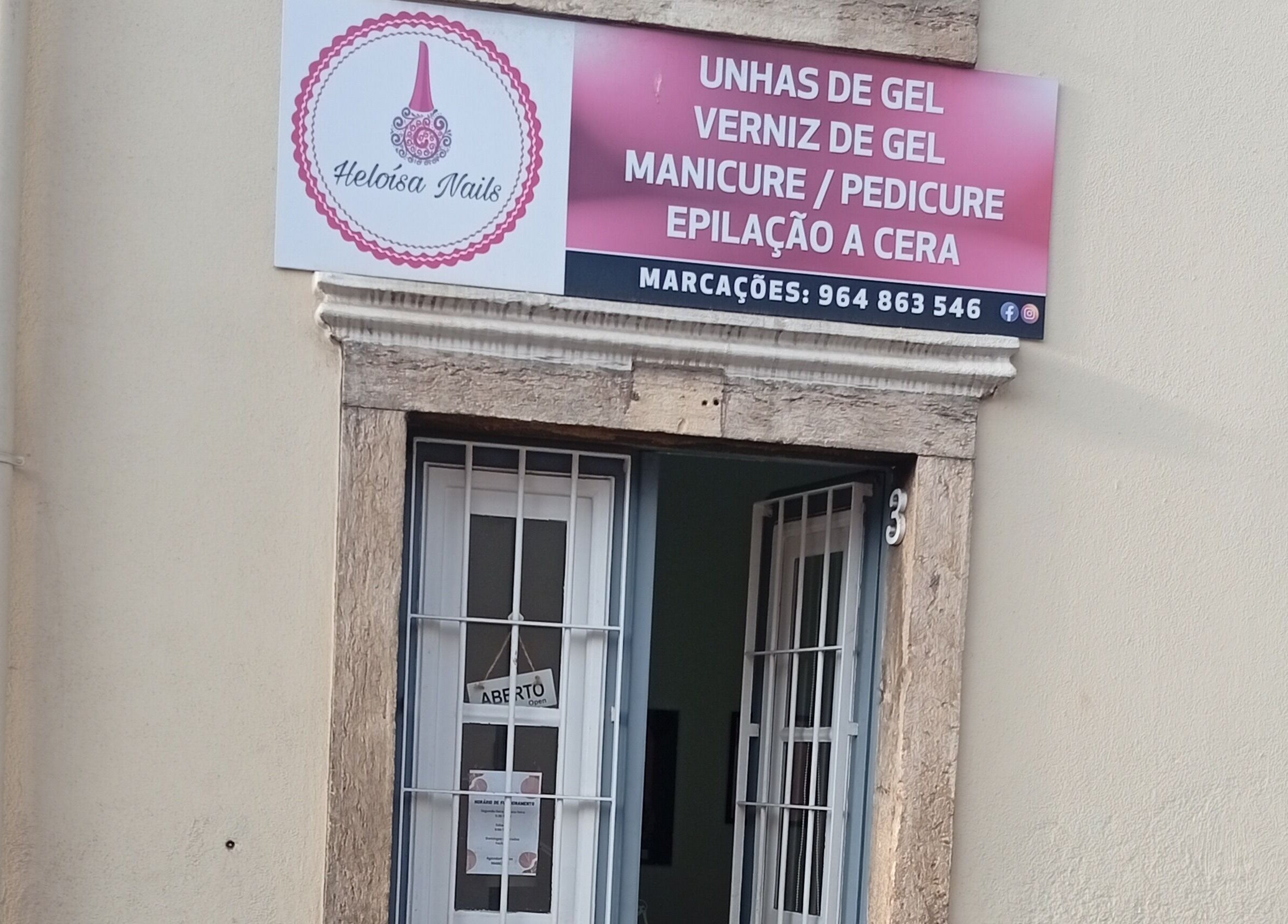 Entrada de Heloísa Nails Salon em Lisboa, Lisboa, PT com placa destacando serviços de manicure e pedicure.