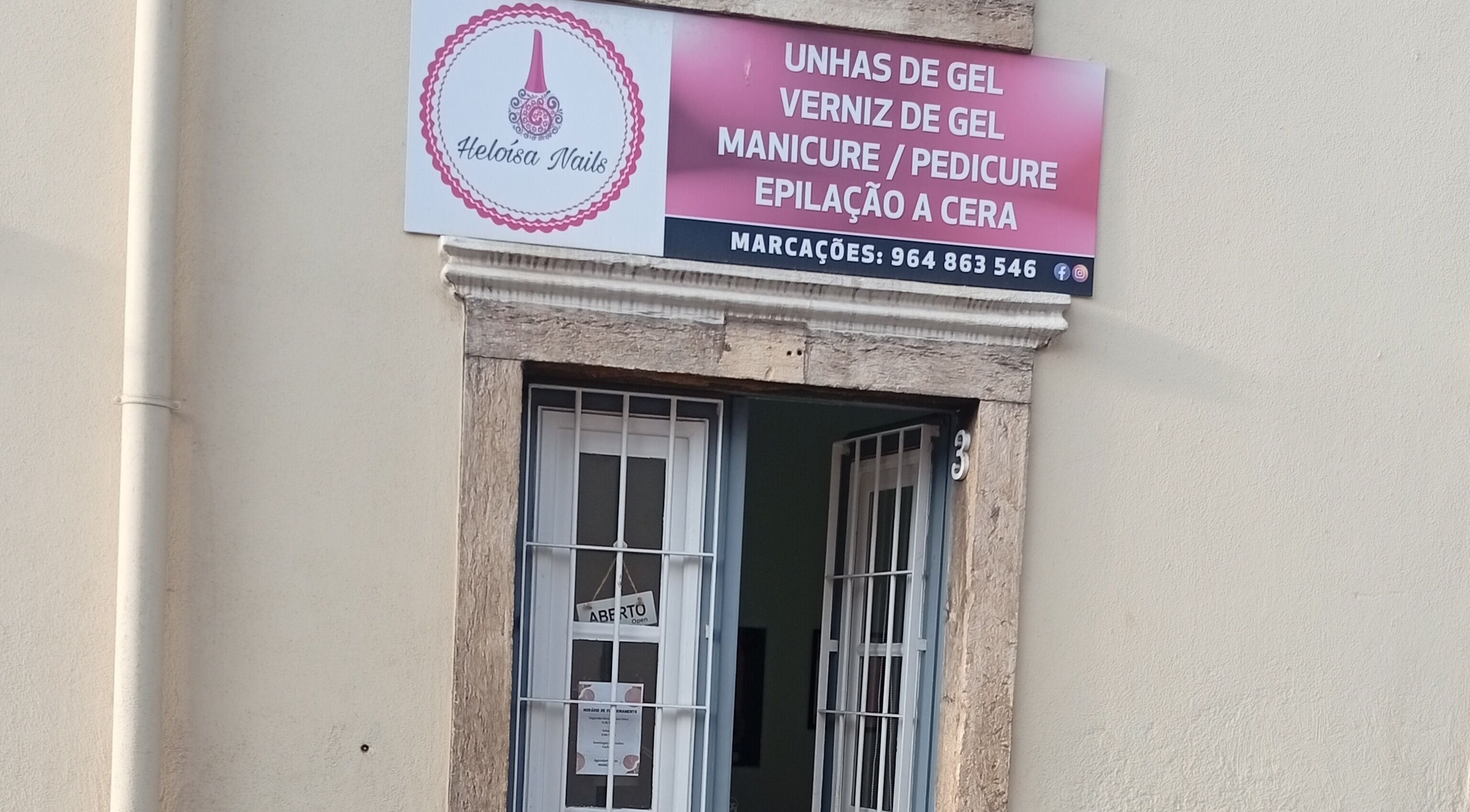 Entrada de Heloísa Nails Salon em Lisboa, Lisboa, PT com placa destacando serviços de manicure e pedicure.