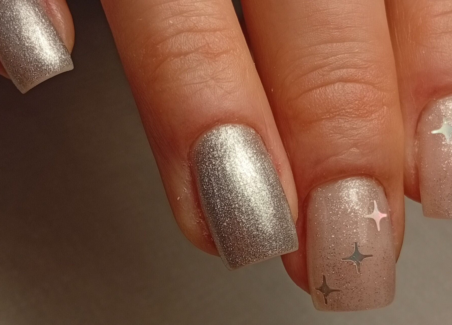 Esmalte prateado com estrelas de Heloísa Nails Salon, Lisboa, Lisboa, PT.
