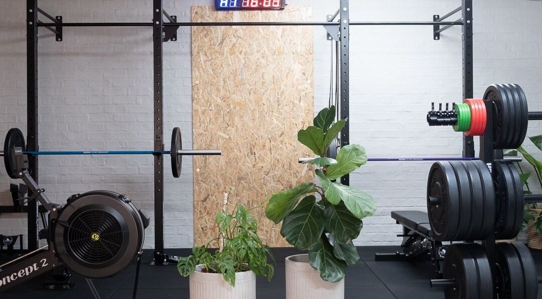 Modern gym setup at Seal Hybrid Performance, Cape Saint Francis, Eastern Cape, ZA featuring weights and plants.