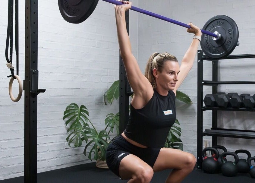 Woman weightlifting at Seal Hybrid Performance, Cape Saint Francis, Eastern Cape, ZA in modern gym setting.