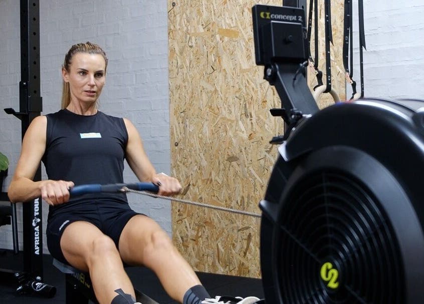 Woman exercising on a rowing machine at Seal Hybrid Performance, Cape Saint Francis, Eastern Cape, ZA.