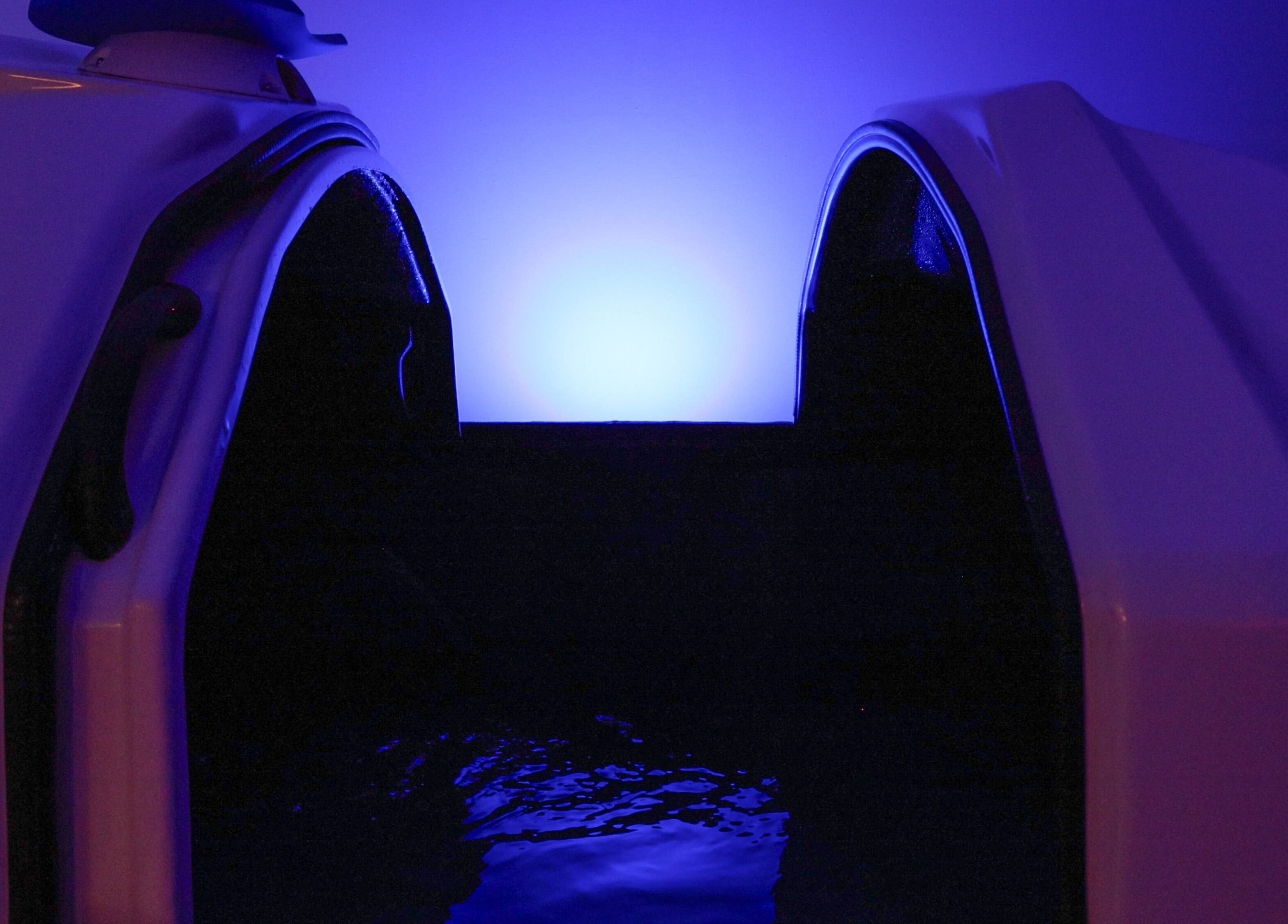 Relaxing float tank at Breathe WRL, Glenelg East, South Australia, AU, illuminated by soothing blue light.