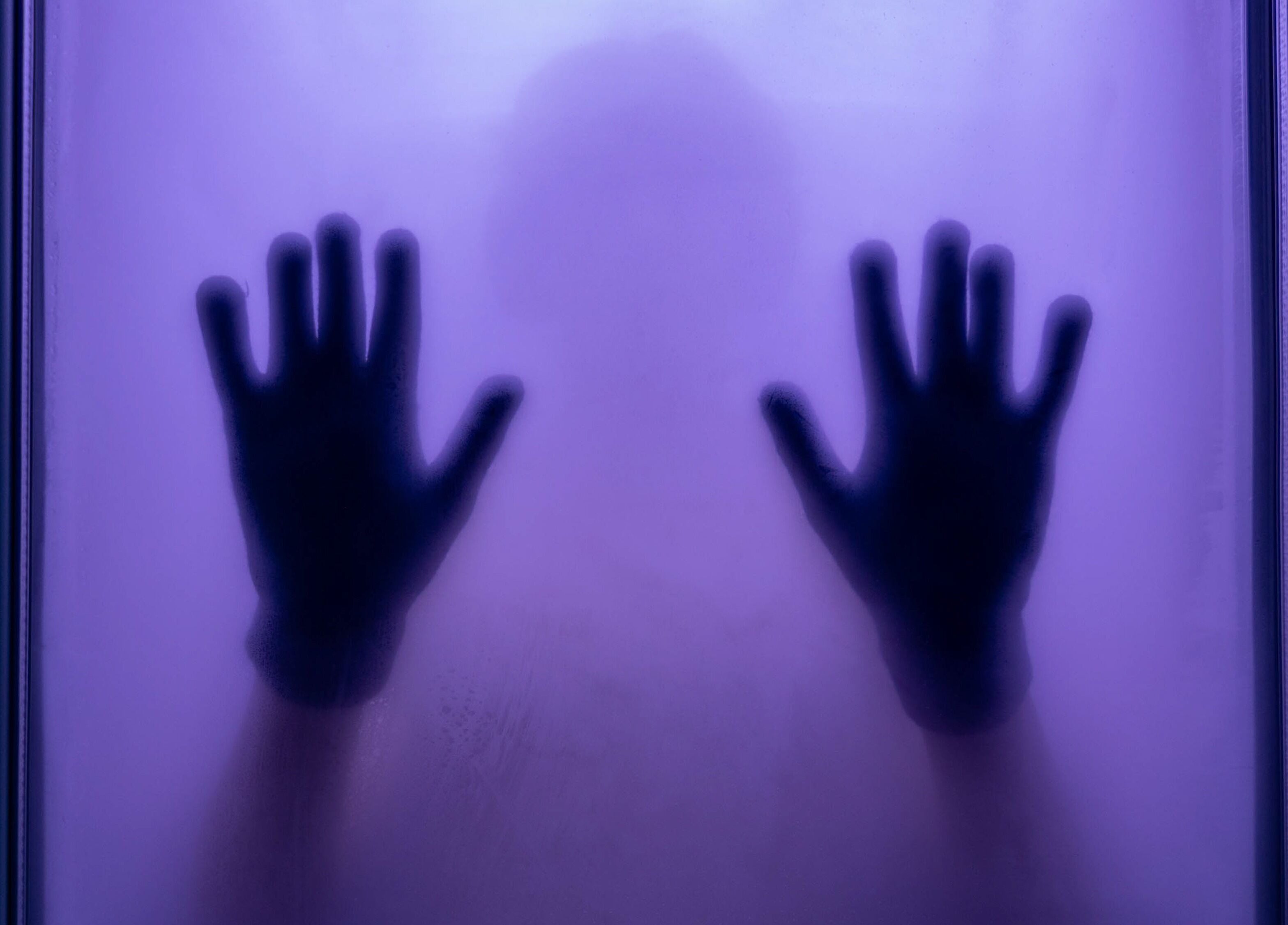 Silhouette of hands against misty purple glass at Breathe WRL, Glenelg East, South Australia, AU.
