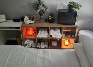 Tays Massage in Griffin, Queensland, AU showcases a serene room with rolled towels, candles, and a Himalayan salt lamp.