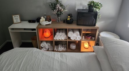 Tays Massage in Griffin, Queensland, AU showcases a serene room with rolled towels, candles, and a Himalayan salt lamp.