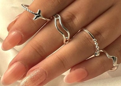 Mão com anéis prateados e unhas elegantes em Bina Sousa Equilíbrio e Bem-Estar, Valongo, Porto, PT.