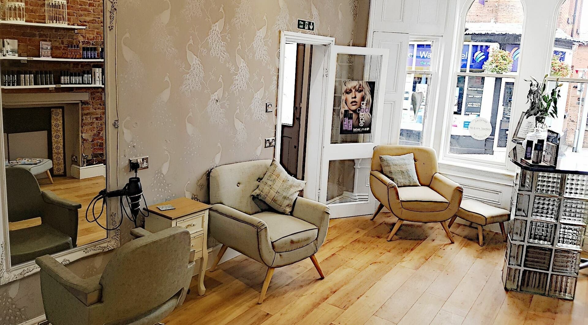 Elegant salon interior at Halo, Congleton, England, GB featuring stylish chairs and wooden flooring.