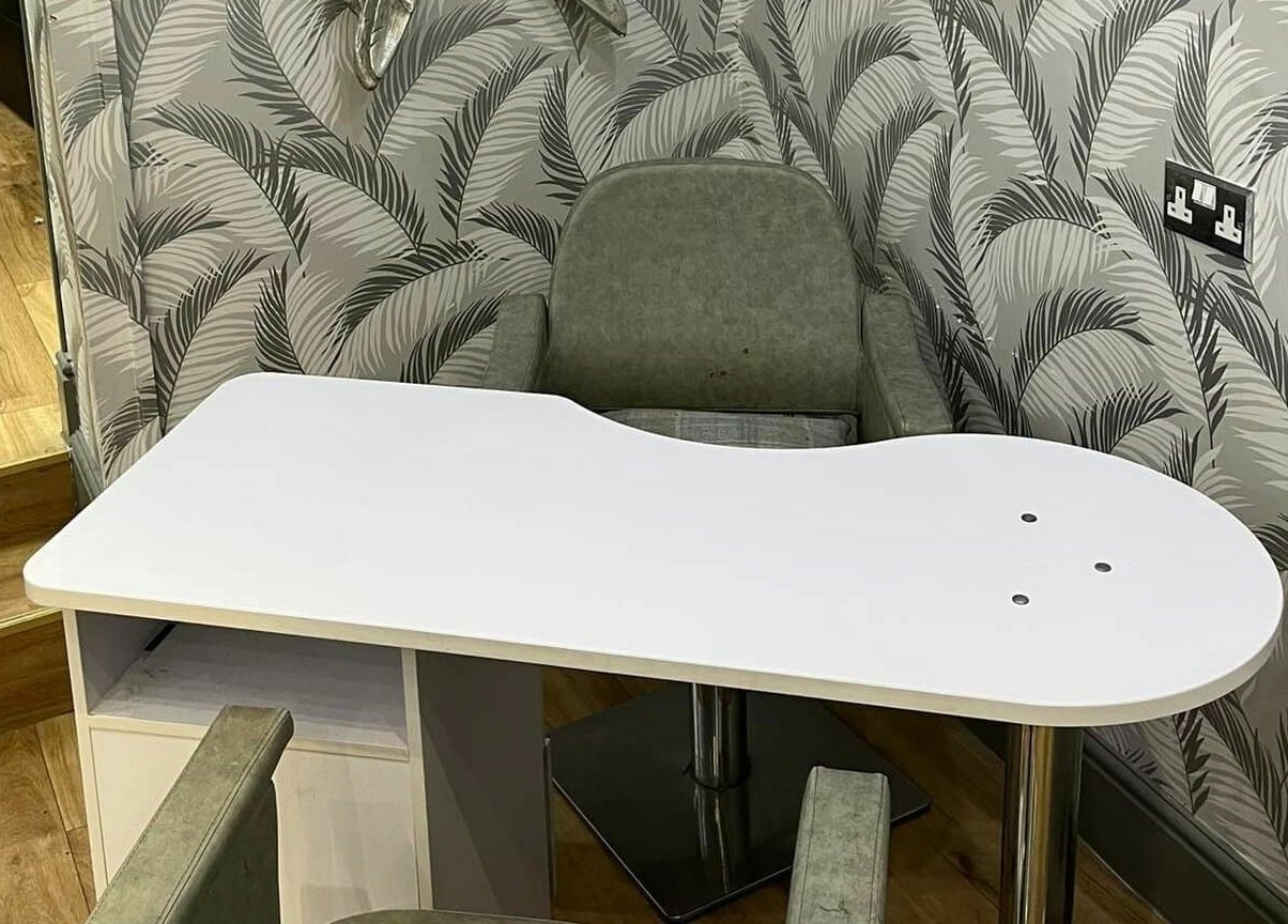 Modern nail table at Halo in Congleton, England, GB with chic palm wallpaper backdrop.