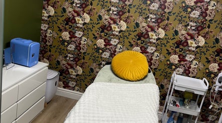 Tranquil treatment room at Ella Bella Beauty, Leek, England, GB with vibrant floral wallpaper and cozy bed.