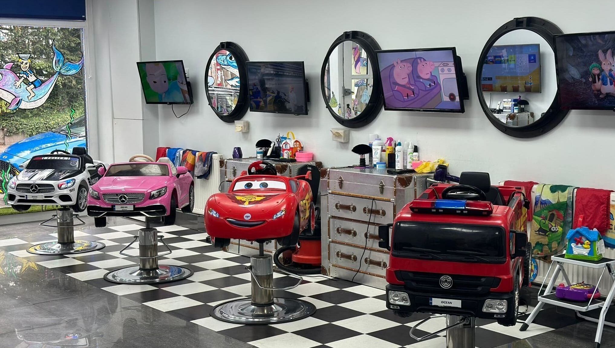 Bright car-themed salon chairs for kids at Ocean Kids and Family Salon, Radlett, England, GB.