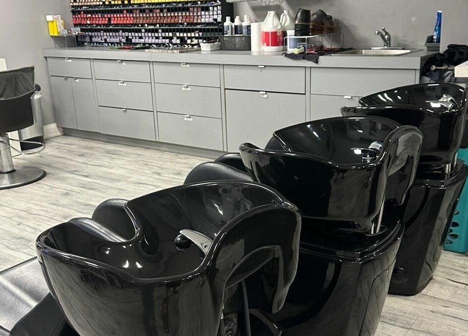 Modern hair washing stations at Hairxtacy Salon in Burlington, Ontario, CA, with sleek black chairs.
