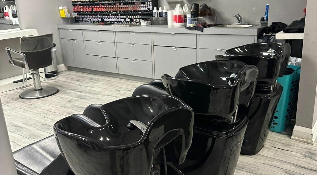 Modern hair washing stations at Hairxtacy Salon in Burlington, Ontario, CA, with sleek black chairs.