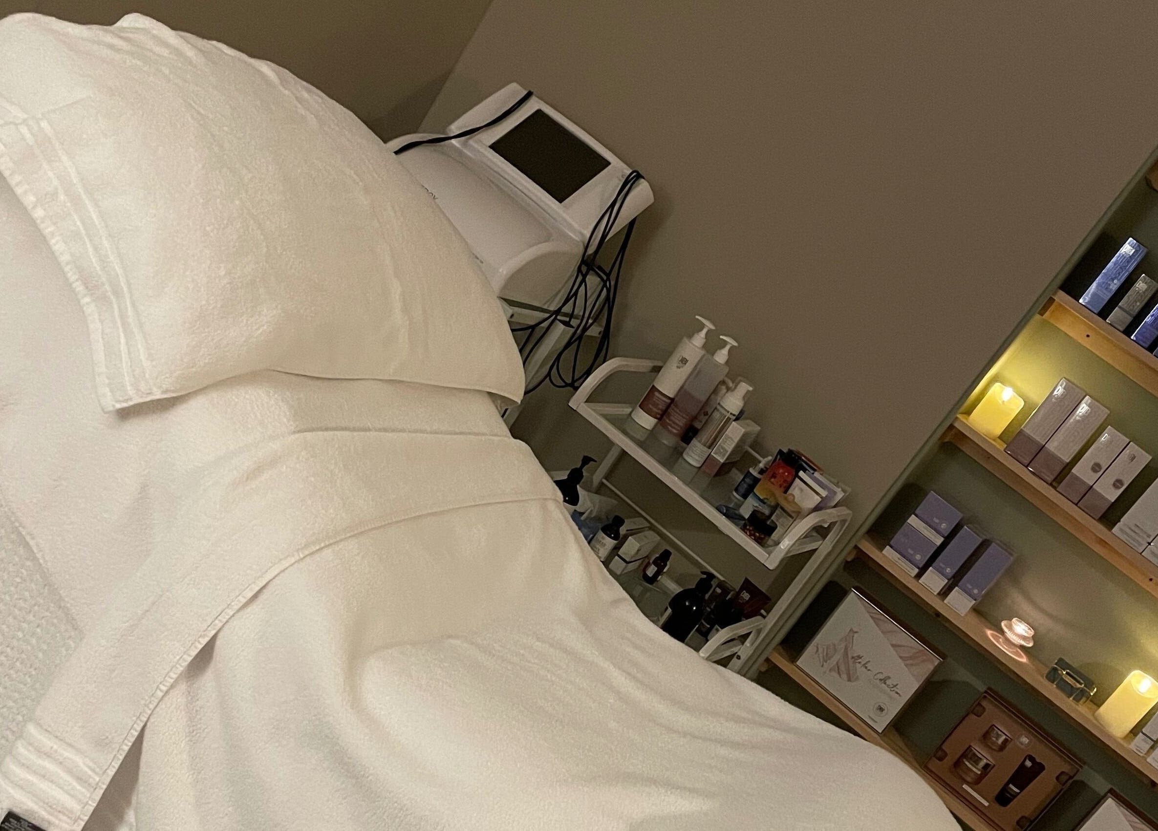 Cozy treatment room at The Skin Corner by Amy in Shaftesbury, England, GB, showcasing plush bedding and skincare products.