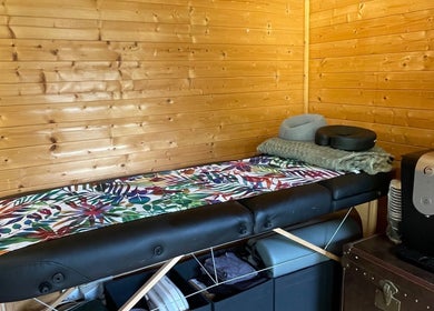 Cozy massage room at Green Cabin Beauty at Mill Meadows, Newport, England, GB with a wooden interior.