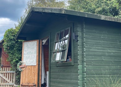 Charming rustic cabin at Green Cabin Beauty, Mill Meadows, Newport, England, GB surrounded by lush greenery.