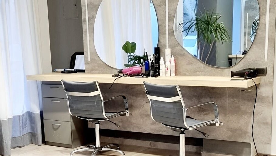 Estación de peinado moderna en Natalia Hairstylist, San Juan, San Juan, AR, con espejos y sillas estilizadas.