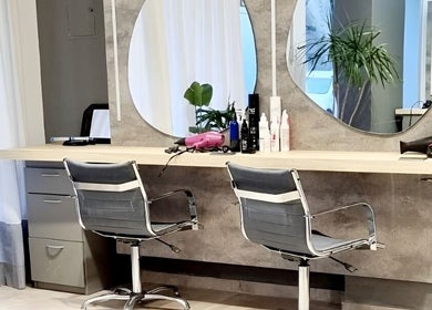 Estación de peinado moderna en Natalia Hairstylist, San Juan, San Juan, AR, con espejos y sillas estilizadas.