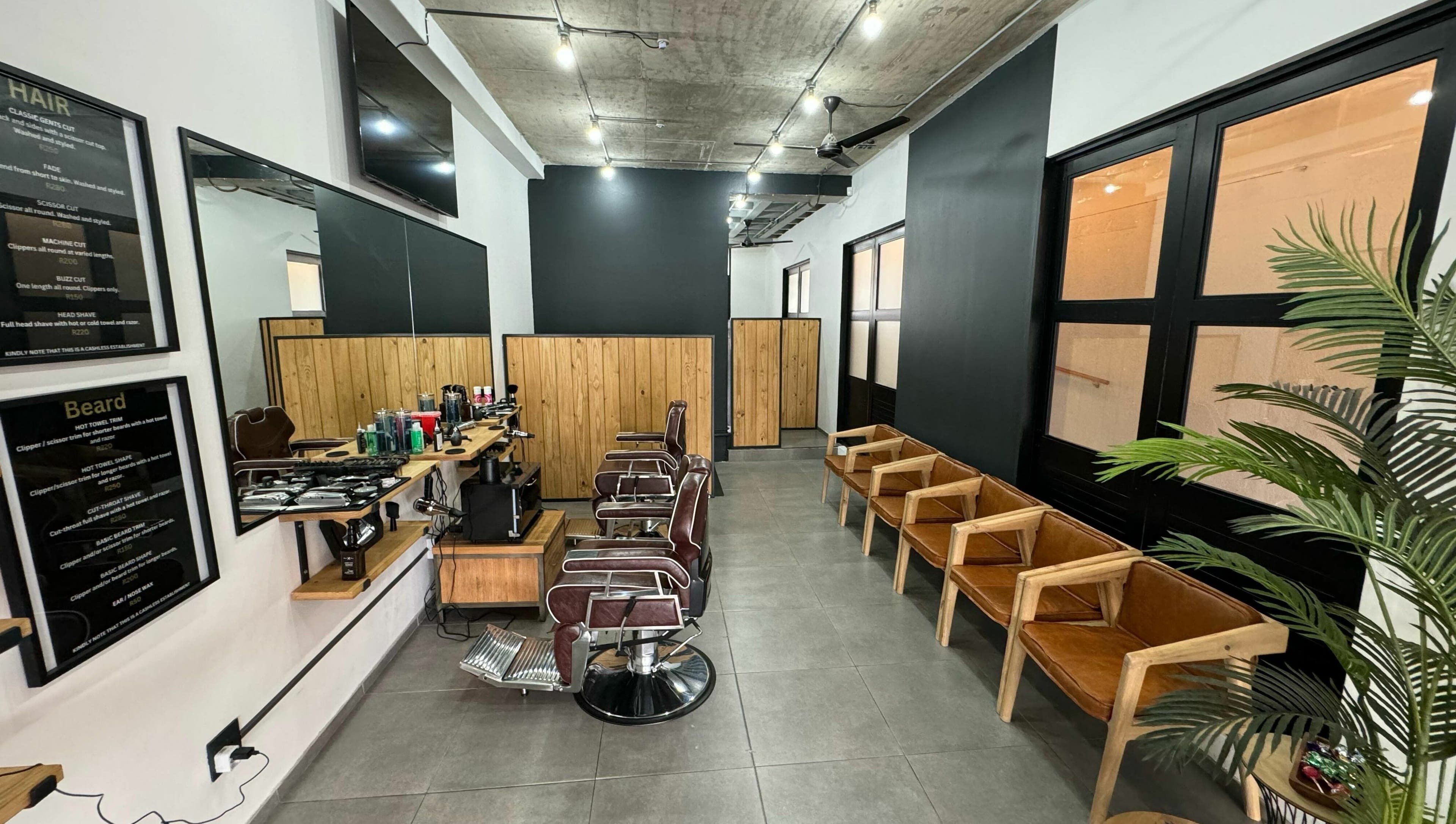 Modern barber shop interior at The Old Harbour Barber in Hermanus, Western Cape, ZA featuring stylish chairs and décor.