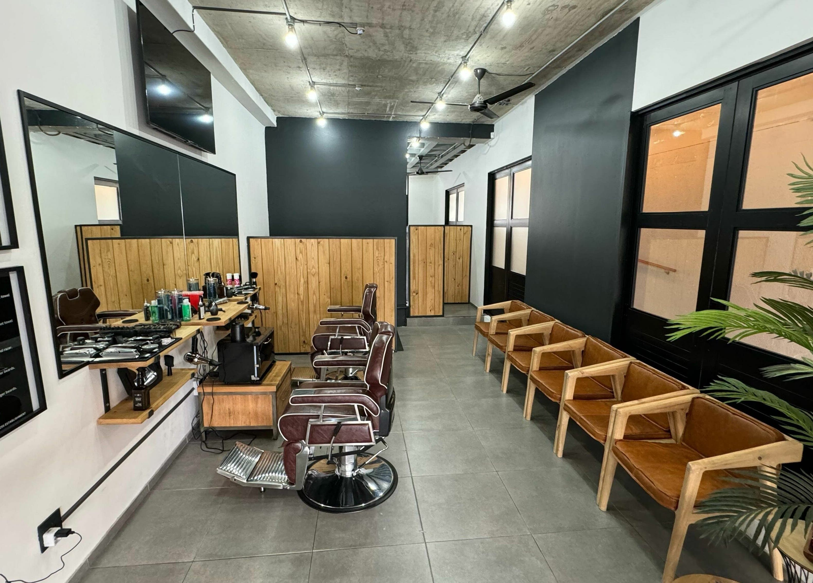 Modern barber shop interior at The Old Harbour Barber in Hermanus, Western Cape, ZA featuring stylish chairs and décor.