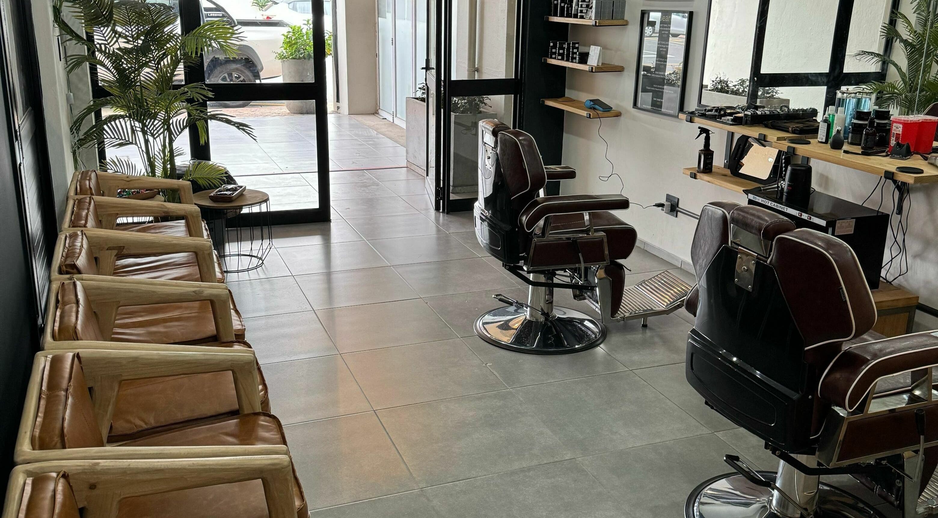 Relaxing interior of The Old Harbour Barber in Hermanus, Western Cape, ZA showcasing chairs and styling area.