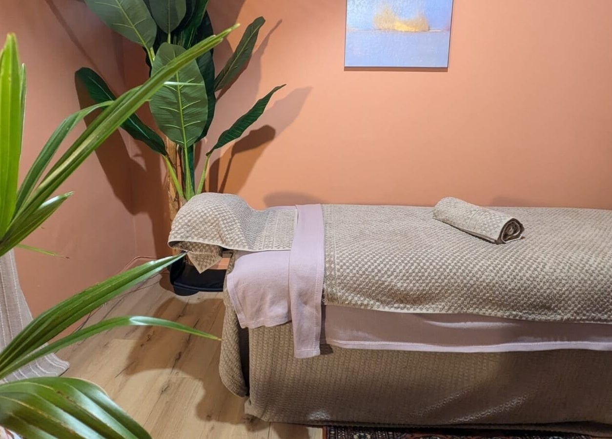 Tranquil massage room with plants and soft linens at Remedy Room West, Glasgow, Scotland, GB.