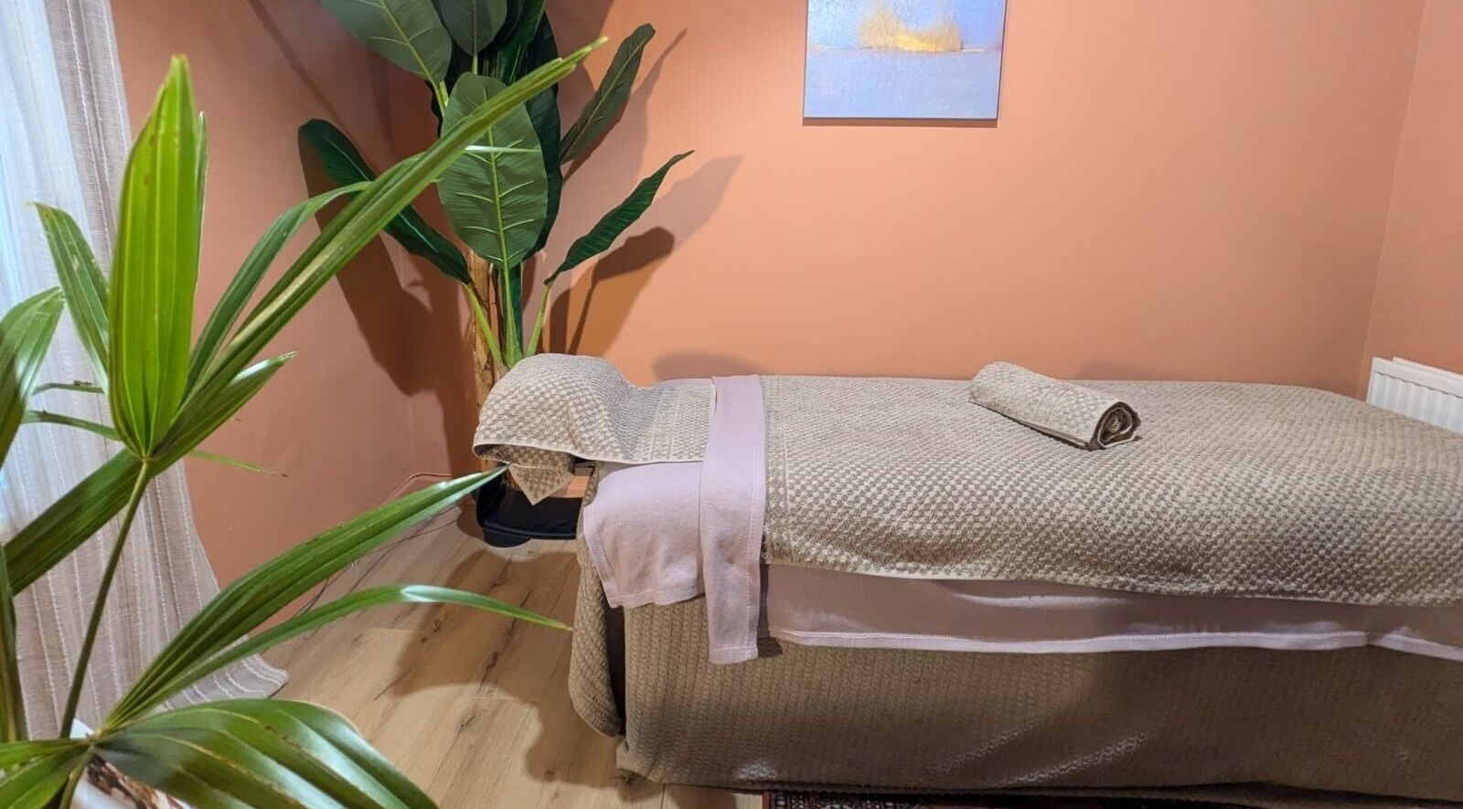 Tranquil massage room with plants and soft linens at Remedy Room West, Glasgow, Scotland, GB.
