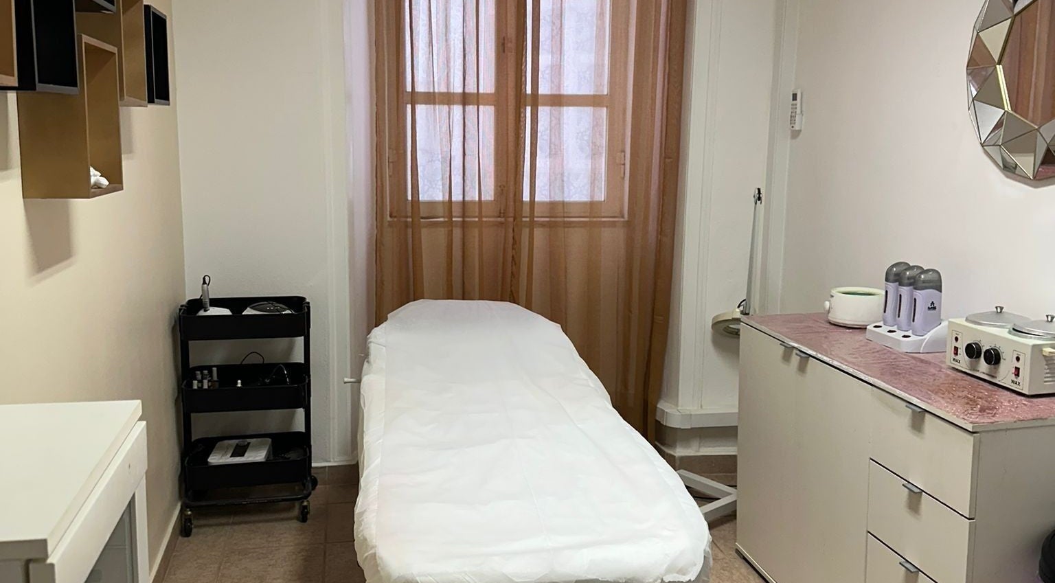 Relaxing treatment room at Kelly's hair & beauty salon, Lagos, Faro, PT, featuring a comfortable bed and serene decor.