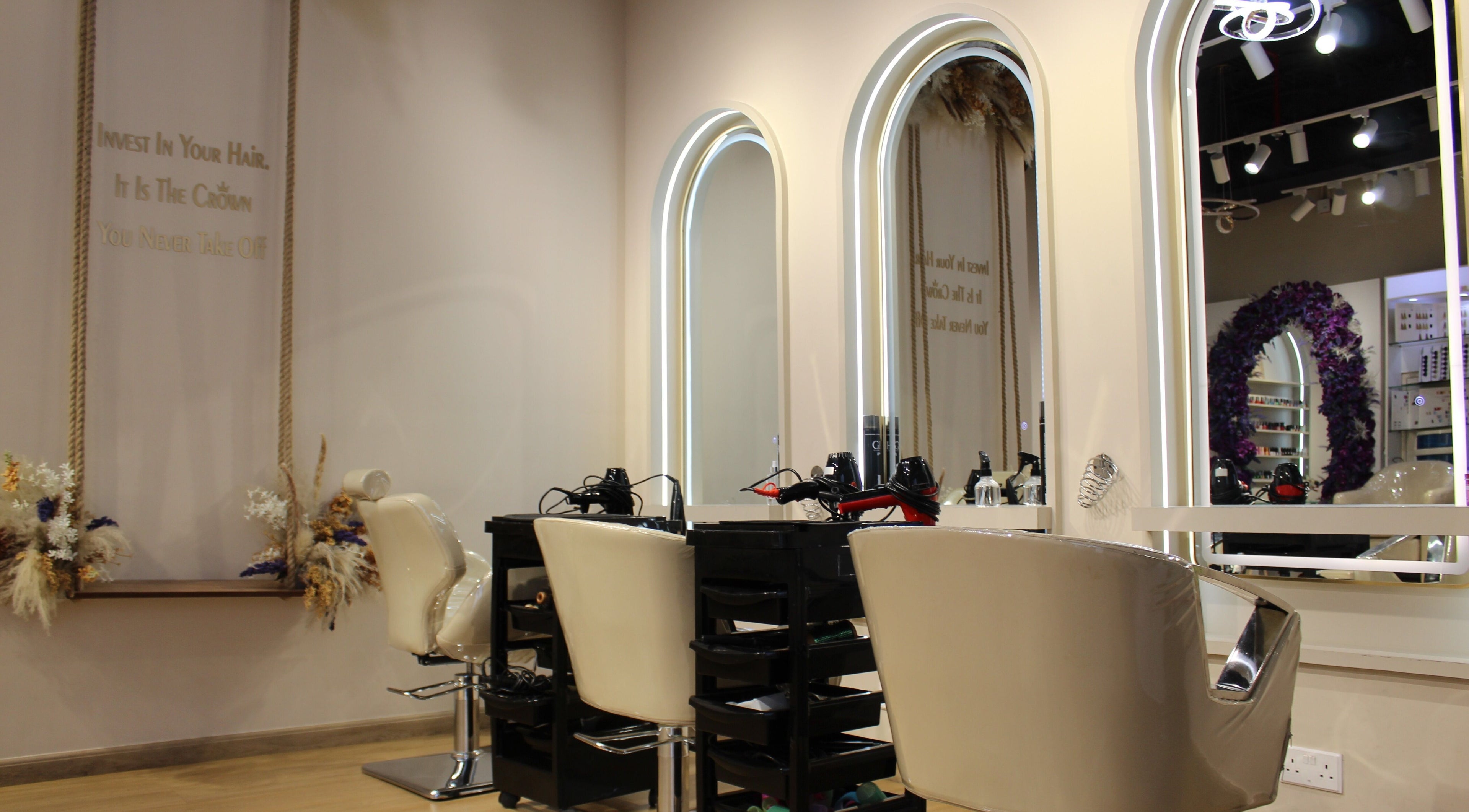 Modern styling stations at Femaled Beauty Salon, Dubai, AE, featuring elegant mirrors and plush chairs.