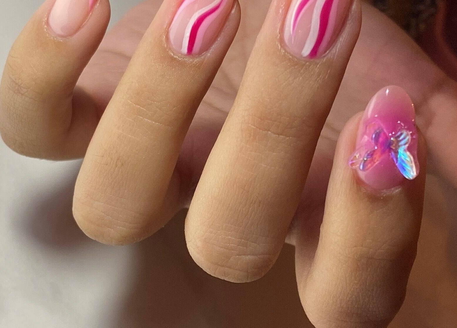 Uñas con diseño rosado y mariposa en Leonails Studio, Providencia, Región Metropolitana, CL.