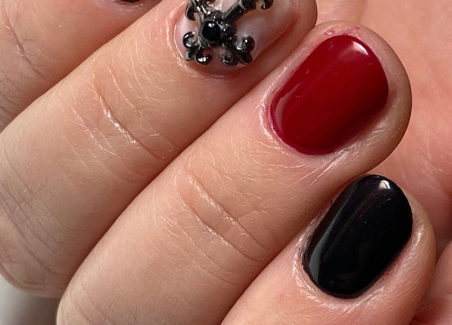 Manicura detallada en Leonails Studio, Providencia, Región Metropolitana, CL, con diseño rojo y negro elegante.