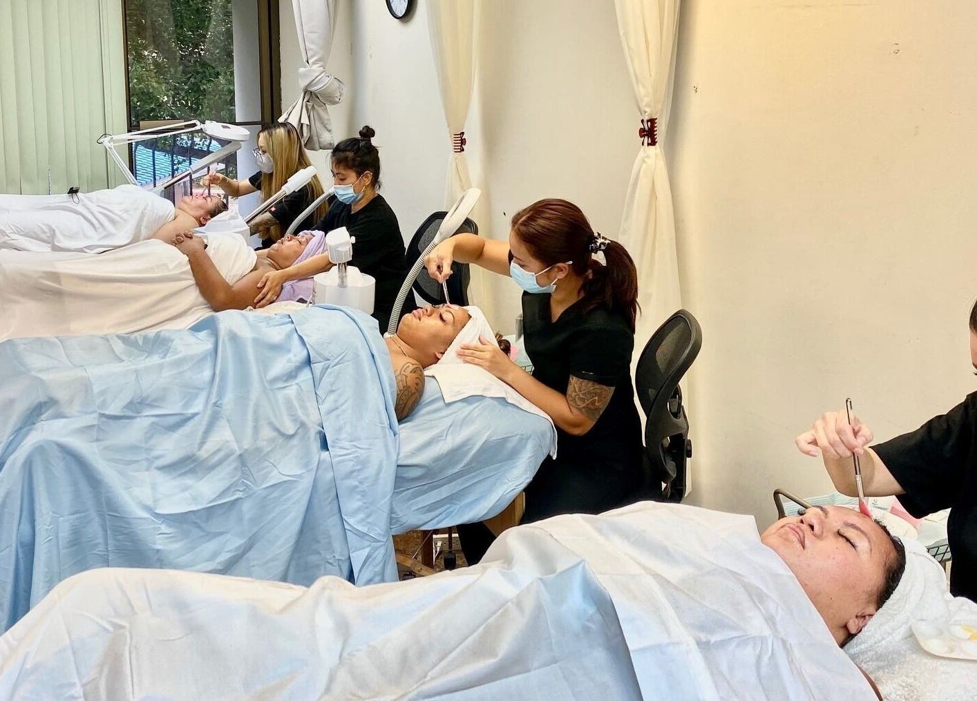 Students at HNA Est Hybrid Online Students in Honolulu, Hawaii, US practice facial treatments in a serene setting.