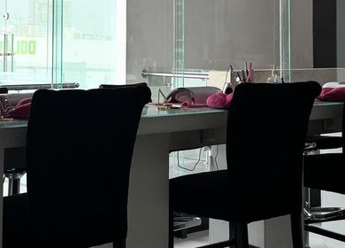 Mesa de belleza en Miss Glam, Reynosa, Tamaulipas, MX con sillas negras y decoraciones rosadas.