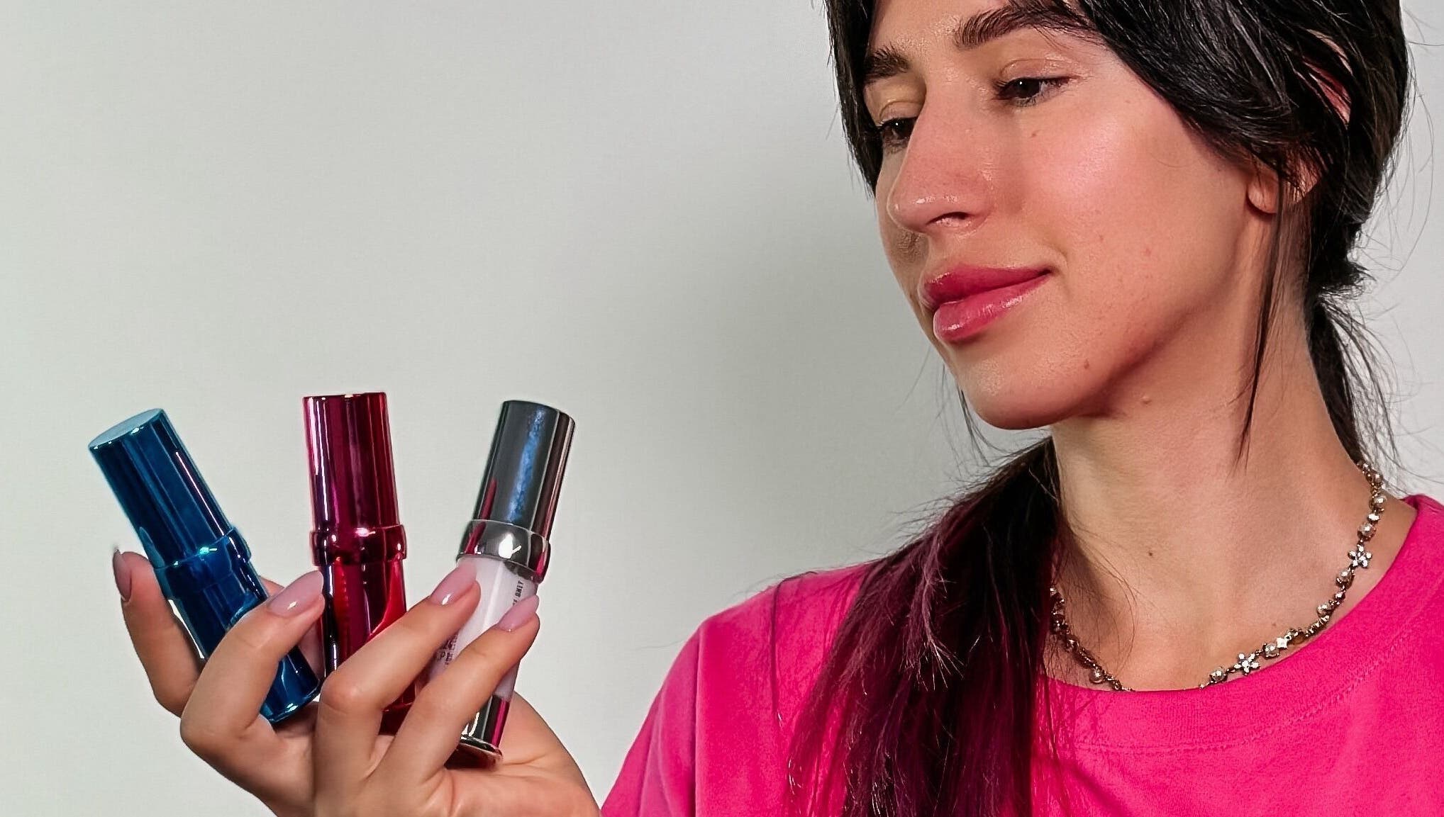 Woman holding vibrant lipsticks at Browow: Brows & Lips That Stay in Melbourne, Victoria, AU.