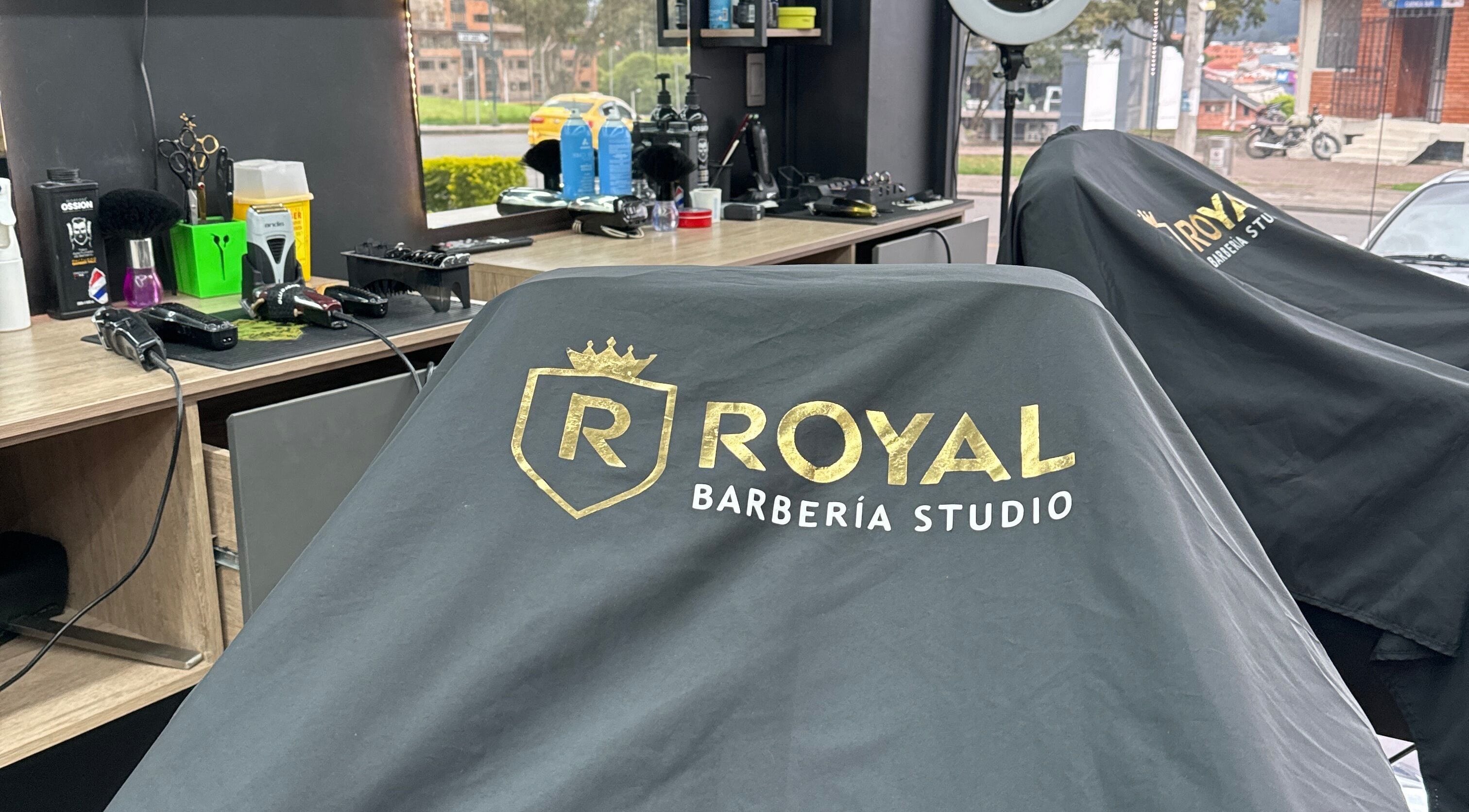 Interior de Royal Barberia en Cuenca, Azuay, EC, mostrando herramientas y capas personalizadas.