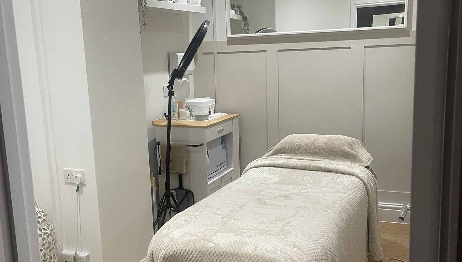 Tranquil treatment room at Harper Victoria Aesthetics, Bristol, England, GB with a cozy bed and soft lighting.