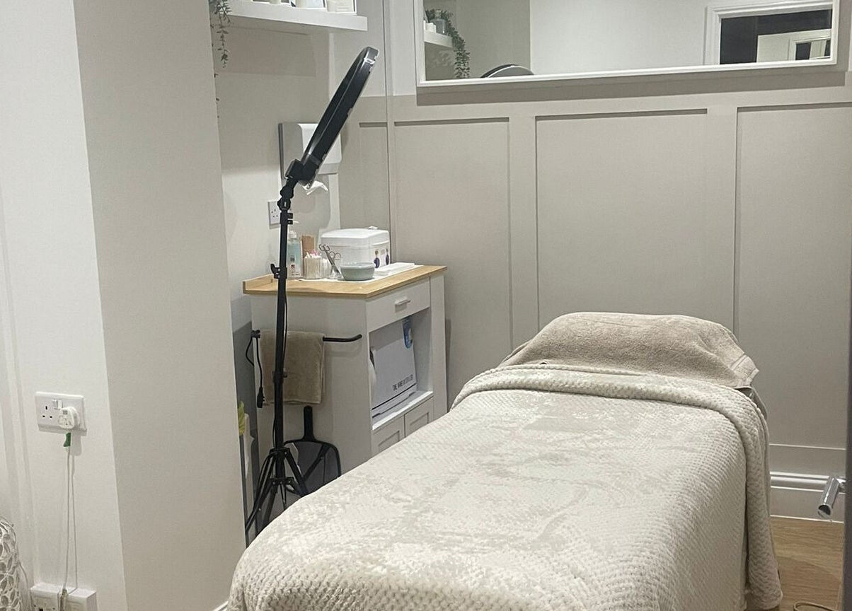 Tranquil treatment room at Harper Victoria Aesthetics, Bristol, England, GB with a cozy bed and soft lighting.