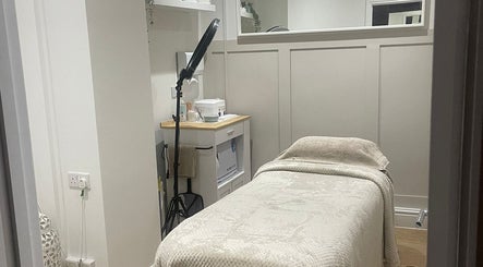 Tranquil treatment room at Harper Victoria Aesthetics, Bristol, England, GB with a cozy bed and soft lighting.